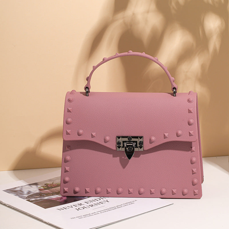 Sac en PVC eprolo Jelly avec rivets colorés, poignée et bandoulière, design diagonale et moderne pour femmes.